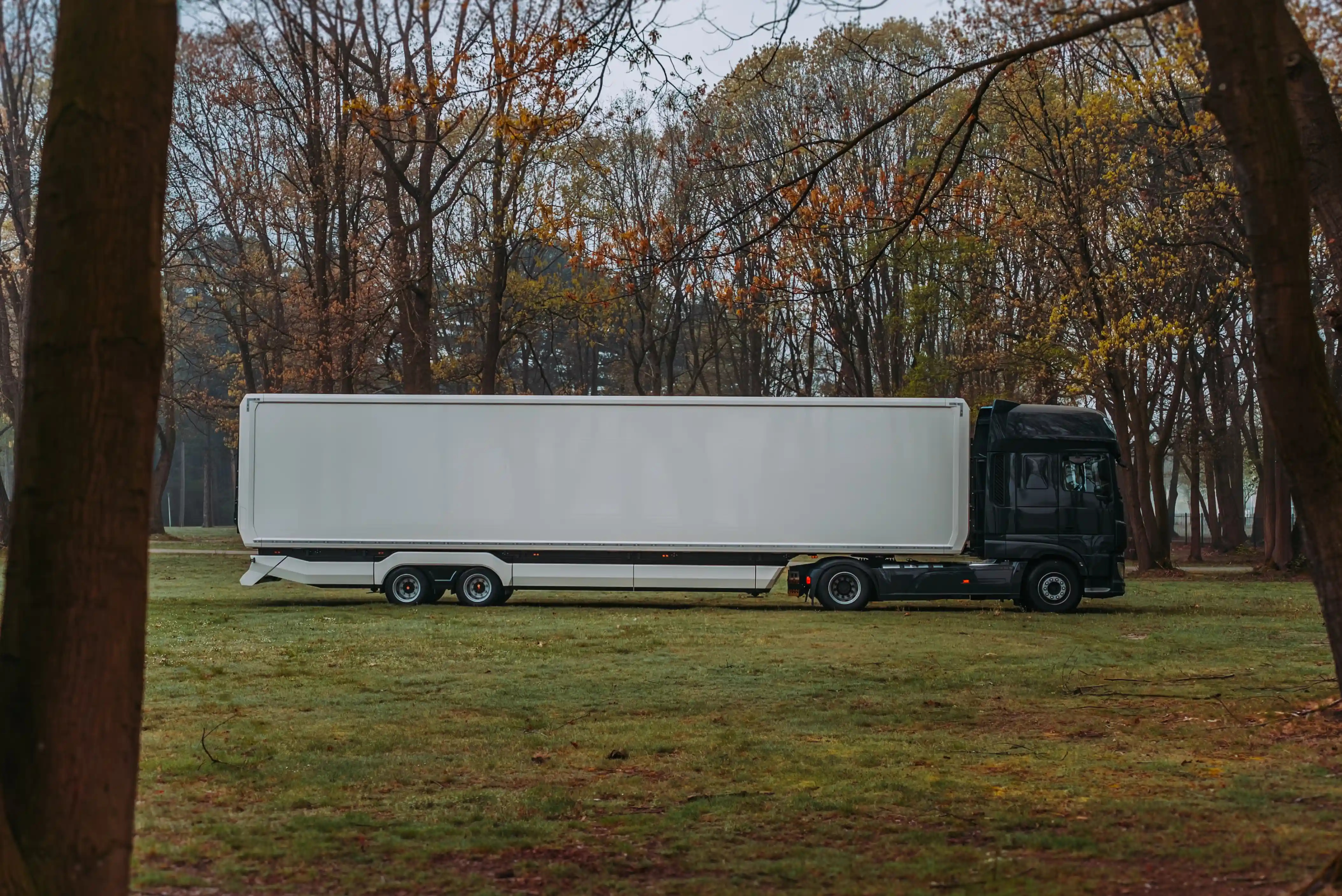 Interior of a mobile hospitality trailer transformed into a command center, equipped with multiple workstations, monitors, and blue mood lighting, with a cityscape wall graphic providing a dynamic backdrop