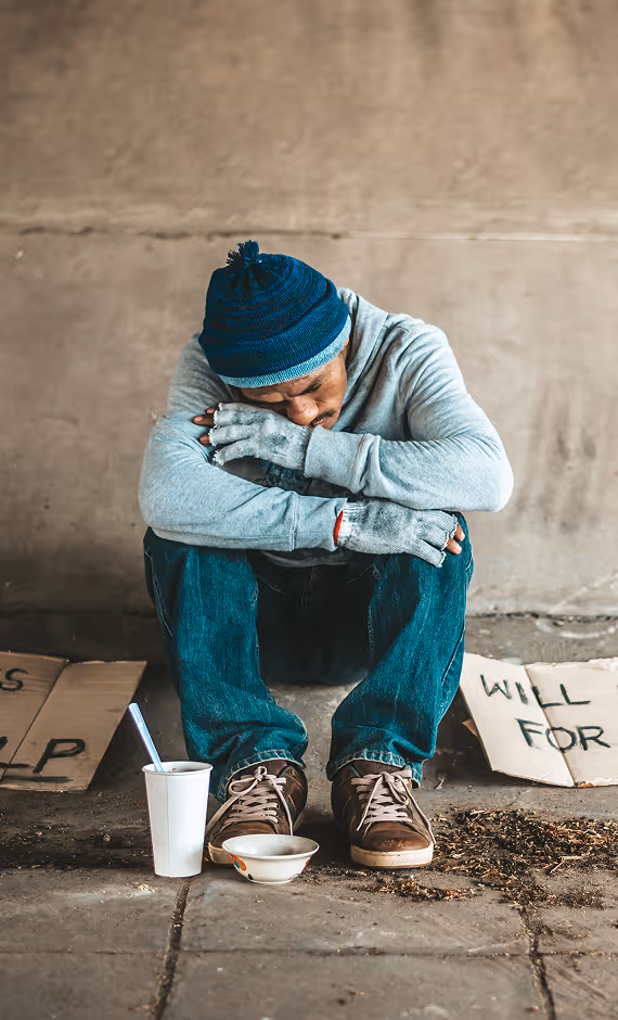 Smiling young boy with curly hair wearing a brown shirt against a light background.
