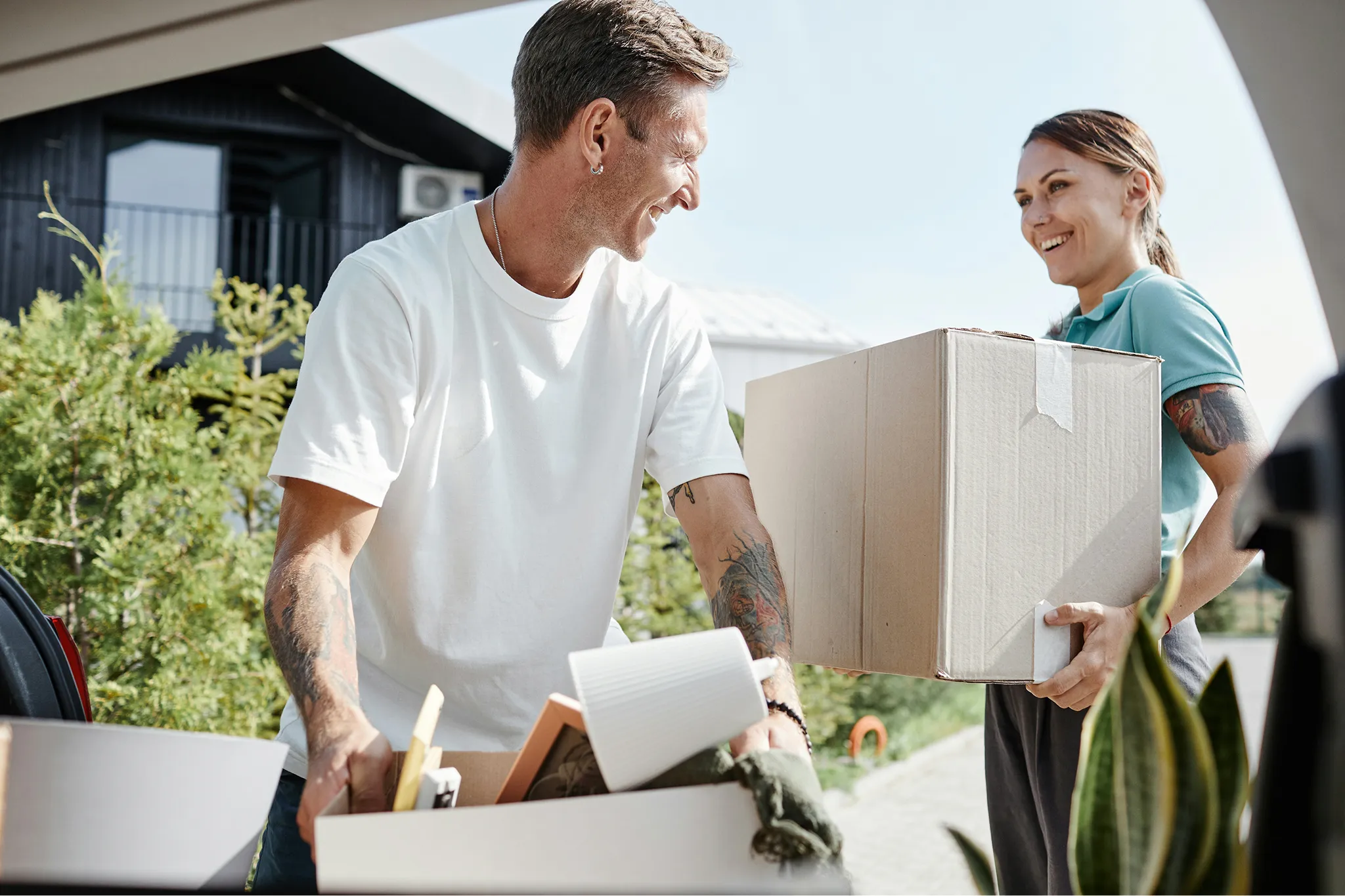 Family of four unpacking moving boxes in a room with cardboard boxes and household items.