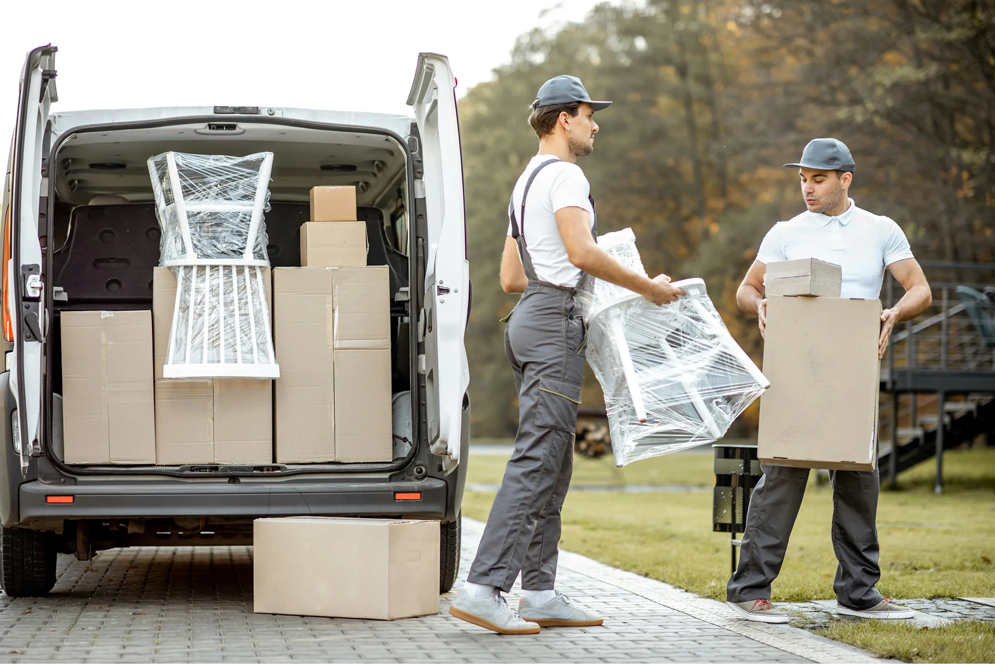 Family unpacking boxes in a new home, sitting on the floor while looking at framed pictures and books.