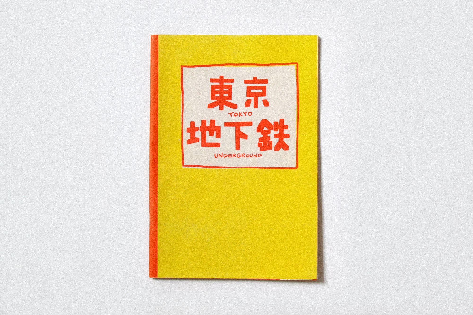 Yellow book with a red spine and a white square on the cover containing Japanese characters and the words 'Tokyo Underground' in red.