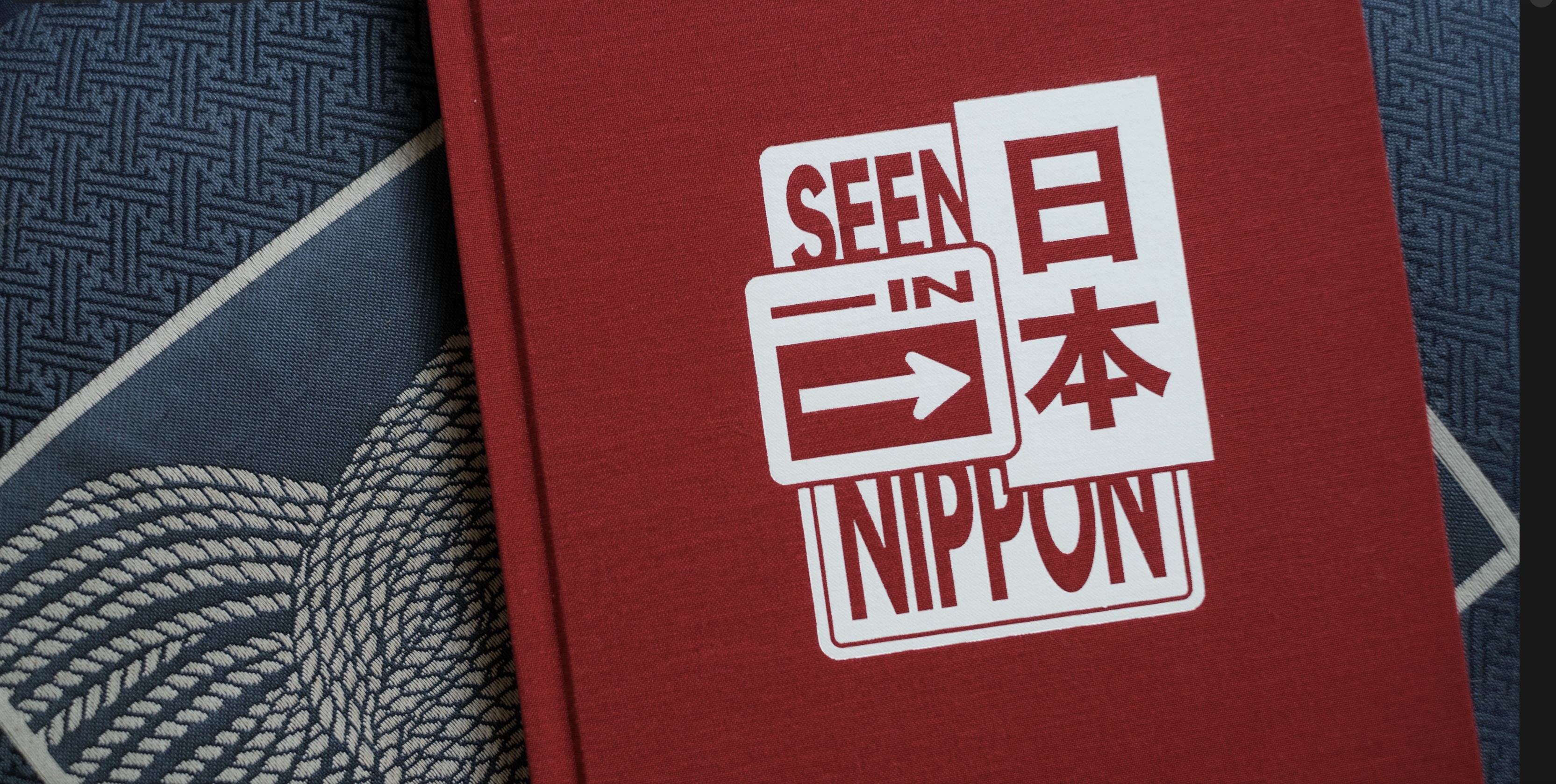 Red book cover with white text reading 'Seen in Nippon' and Japanese characters on blue patterned fabric.