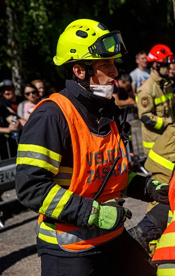 Hasič s neonově žlutou helmou a oranžovou vestou s nápisem VELITEL ZÁSAHU během zásahu.