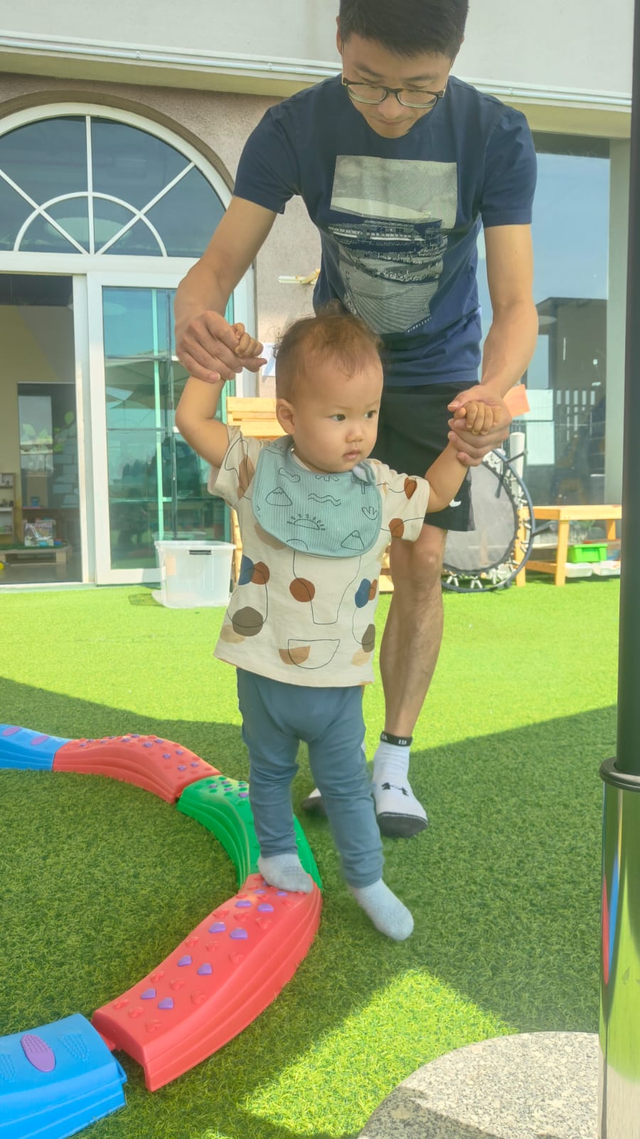 Dad and toddler on the outdoor balance beam