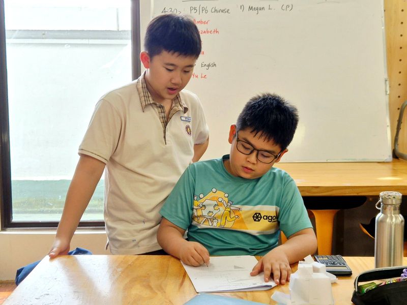 An educator helping a child with written practice