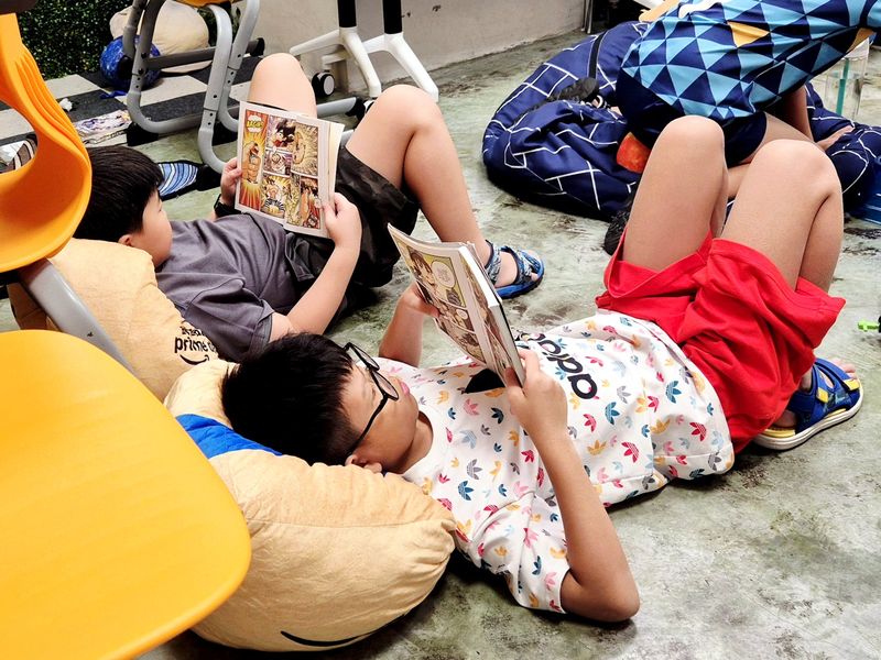 Two children reading on bean bags in the Agora library
