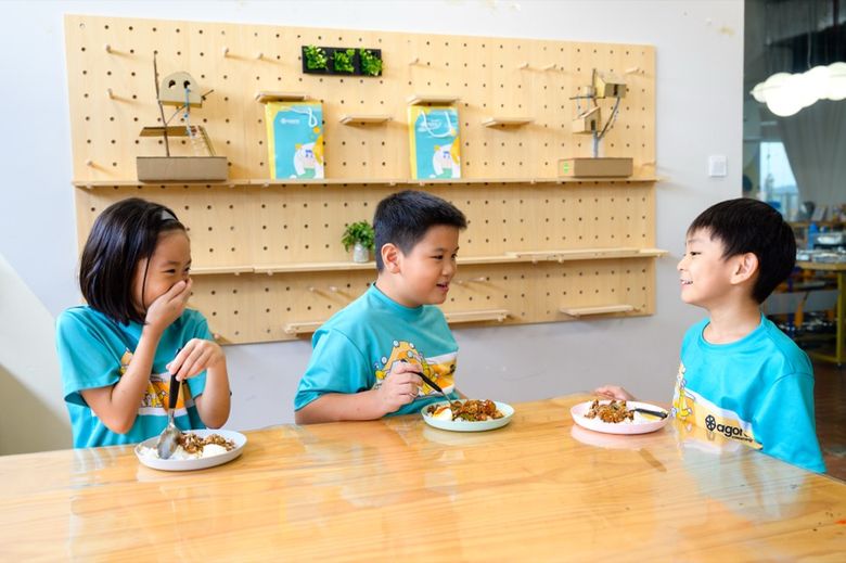 Student Care children eating a hot meal together at Agora