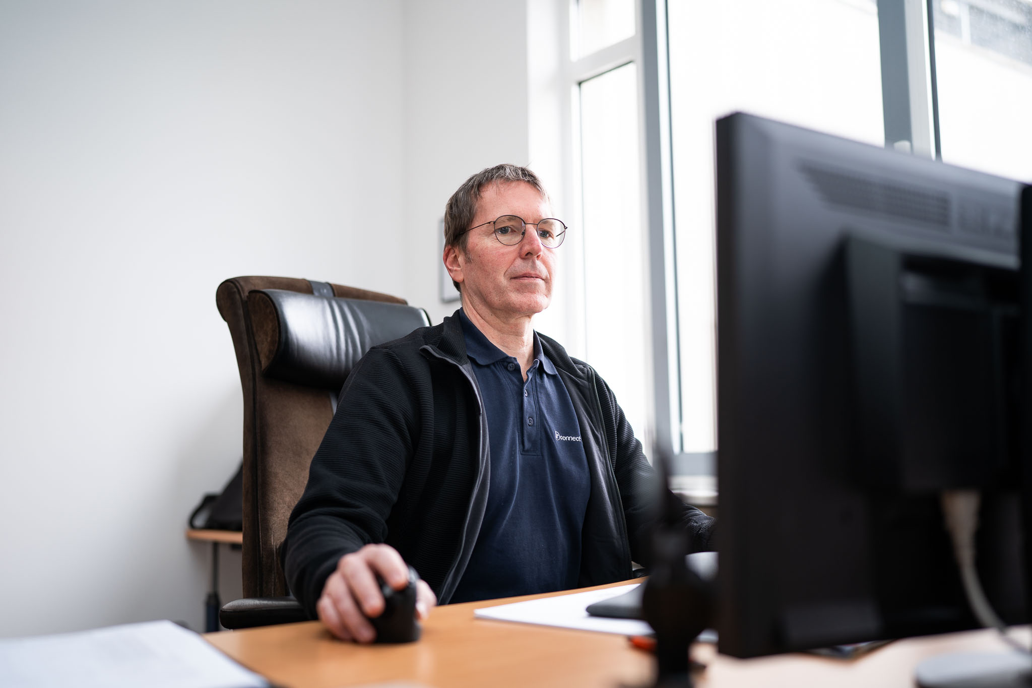 IT-Techniker von connect IT-solutions überwacht Praxis-Systeme am Monitor