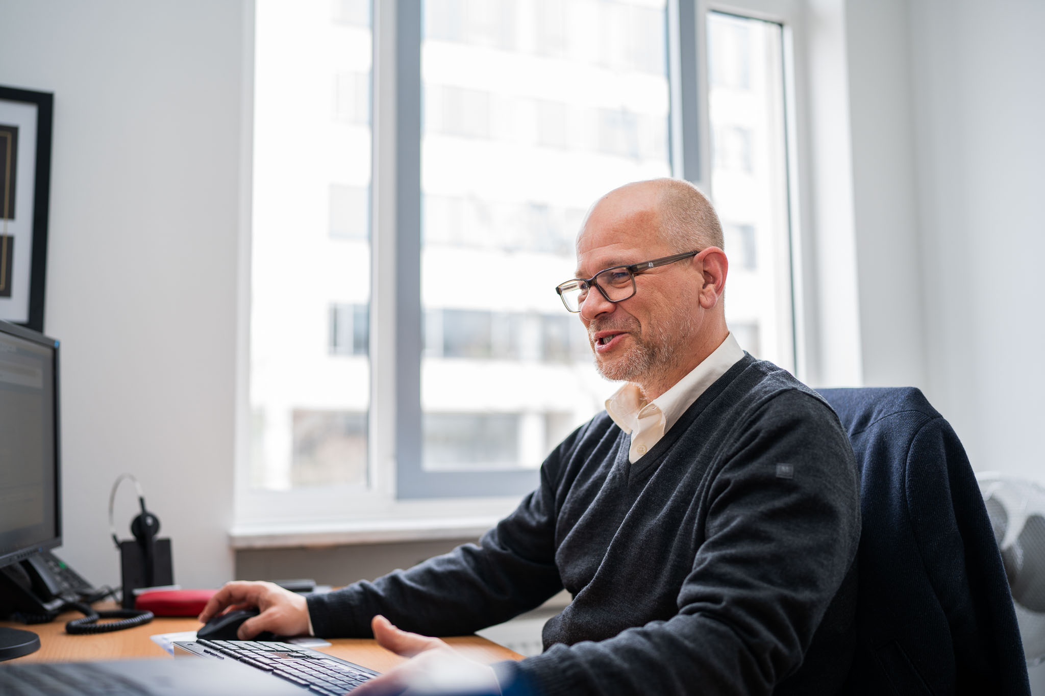 IT-Berater von connect IT-solutions telefoniert am Arbeitsplatz – KI-Telefonassistent für Arztpraxen