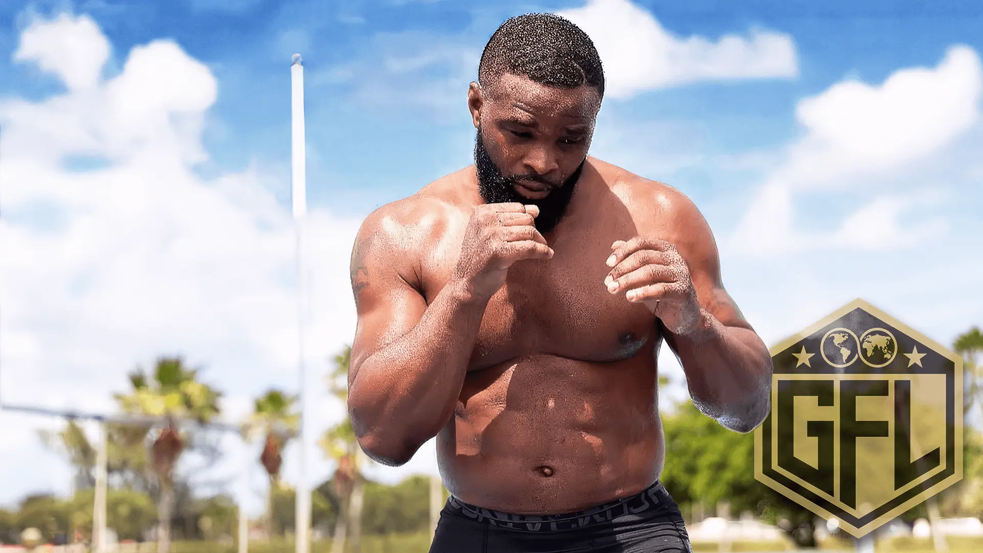 Muscular man shadowboxing outdoors under a blue sky, wearing black shorts, with palm trees and a GFL logo in the background.