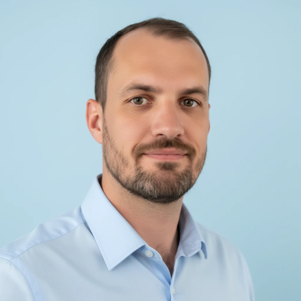 Portrait d'un homme portant une chemise bleue claire, avec un fond bleu uni.