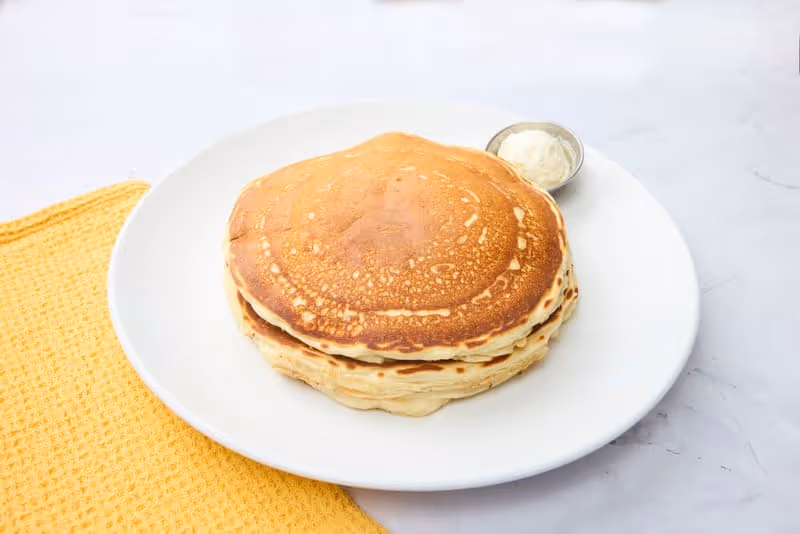 Fluffy, golden, gluten free buttermilk pancakes with a light, airy texture. Served with whipped butter and made to order.