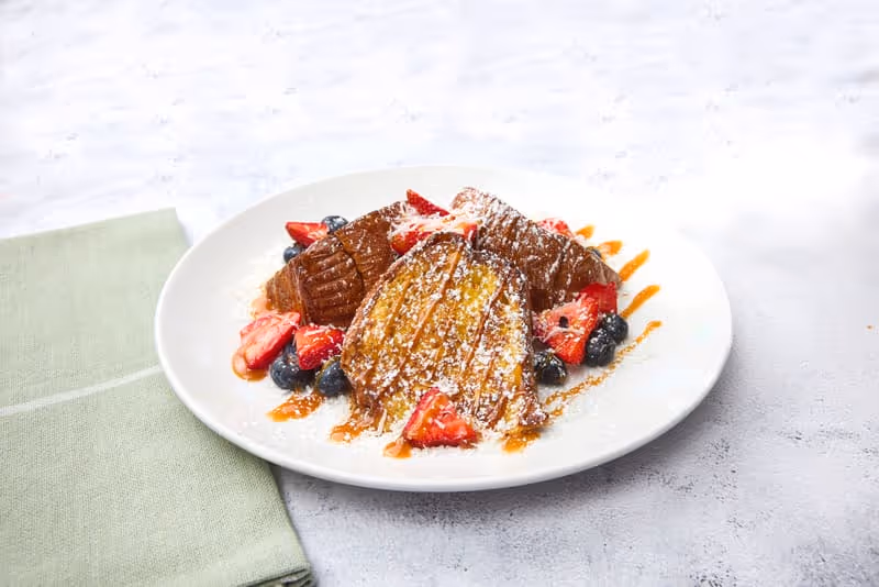 Sweet King’s Hawaiian bread topped with strawberries, blueberries, coconut, caramel sauce and powdered sugar.