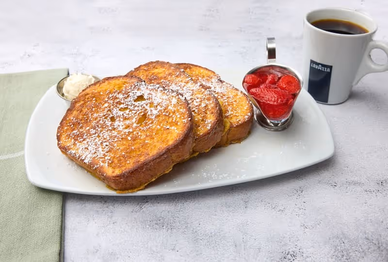 Brioche bread topped with powdered sugar and served with strawberry sauce.