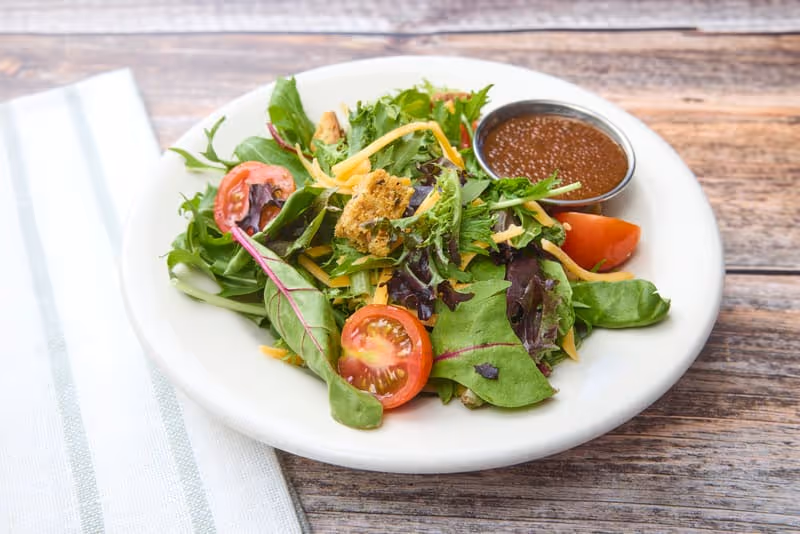 Mixed greens, cherry tomatoes, shredded cheddar cheese, housemade croutons, choice of dressing.