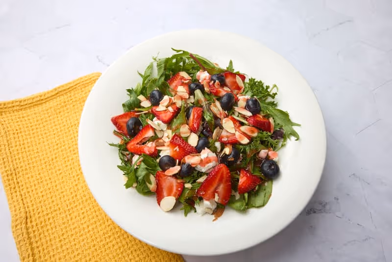 Fresh strawberries and blueberries, sliced almonds, goat cheese and mixed greens with fat-free raspberry vinaigrette.