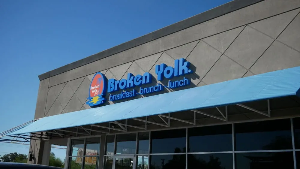 Broken Yolk Cafe Phoenix Camelback interior with colorful sunset mural wall and yellow booth seating