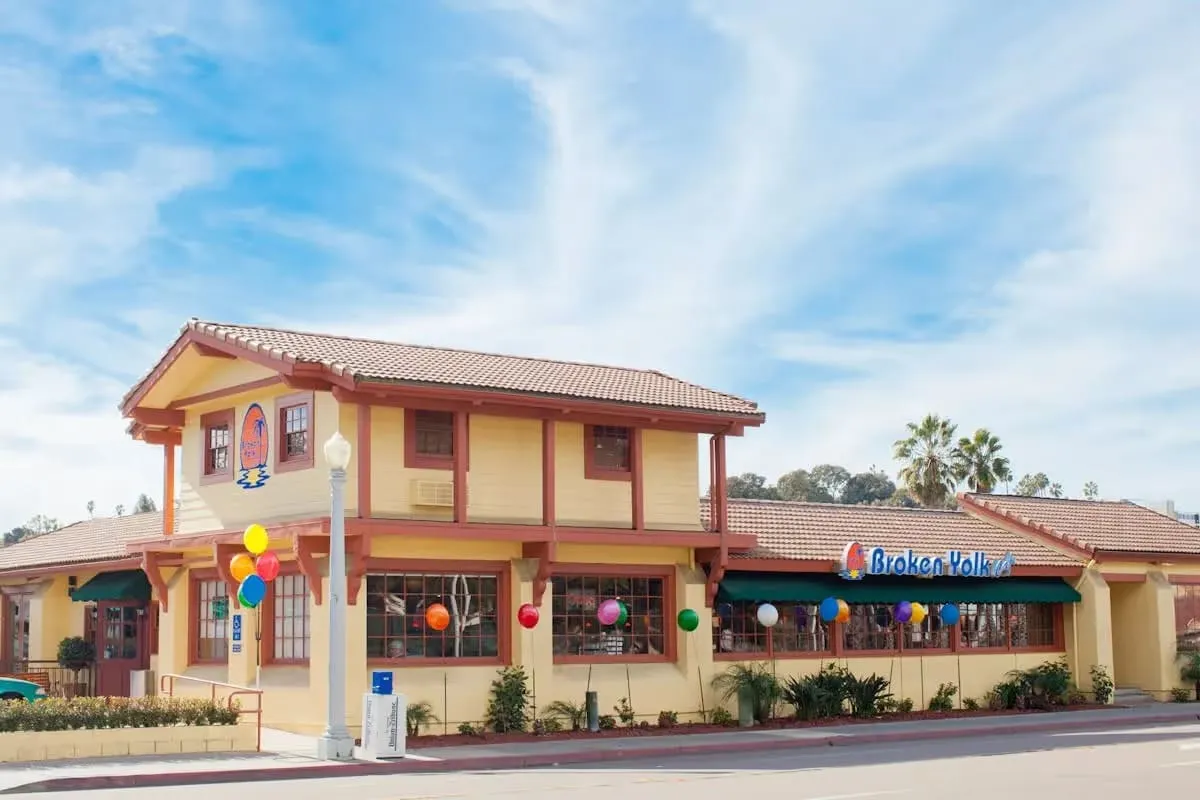 Broken Yolk Cafe Point Loma San Diego exterior with balloons and Spanish-style architecture