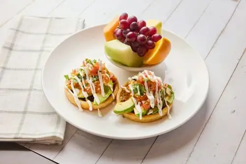 Fried sopes with shredded beef, poached eggs, ranchero sauce, avocado, Cotija cheese, salsa fresca, cilantro and sour cream.
