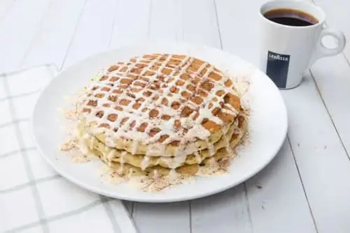 Fluffy, golden buttermilk pancakes swirled with cinnamon-sugar filling, topped with a cream cheese icing drizzle, and finished with a sprinkle of cinnamon.