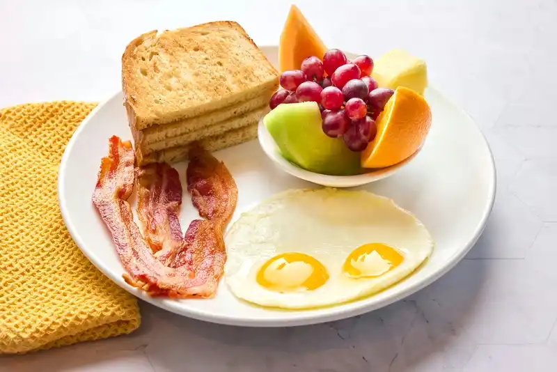 Eggs, side and bread with choice of protein.