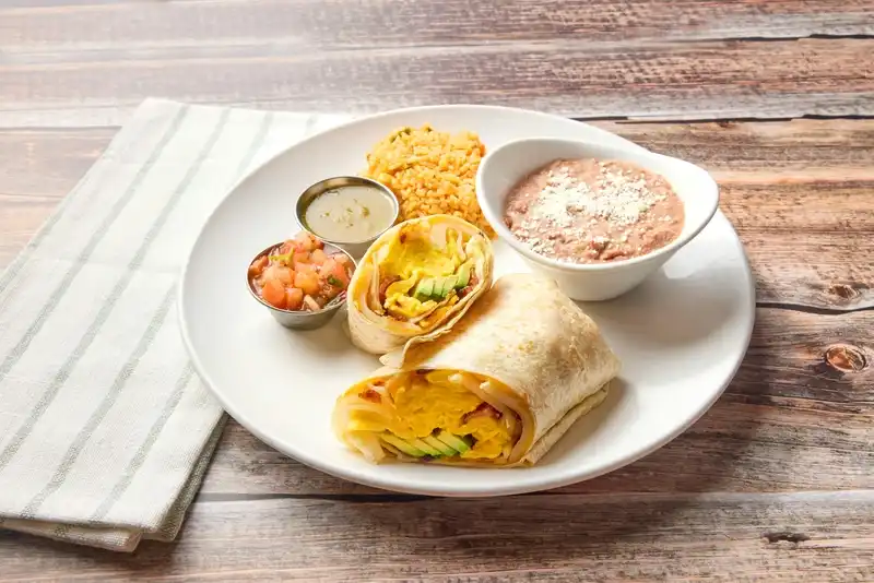 Scrambled eggs, applewood-smoked bacon, cheddar cheese, home fries, and avocado in a flour tortilla. Served with Mexican rice, refried beans, salsa verde and salsa fresca.