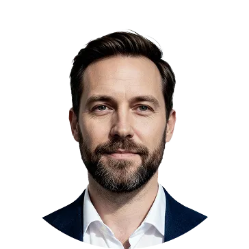 Portrait of a man with dark hair and beard wearing a white shirt and dark blazer.