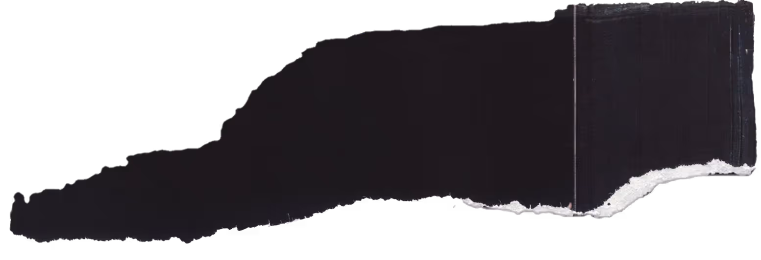 Long torn piece of white paper with rough edges on a black background.