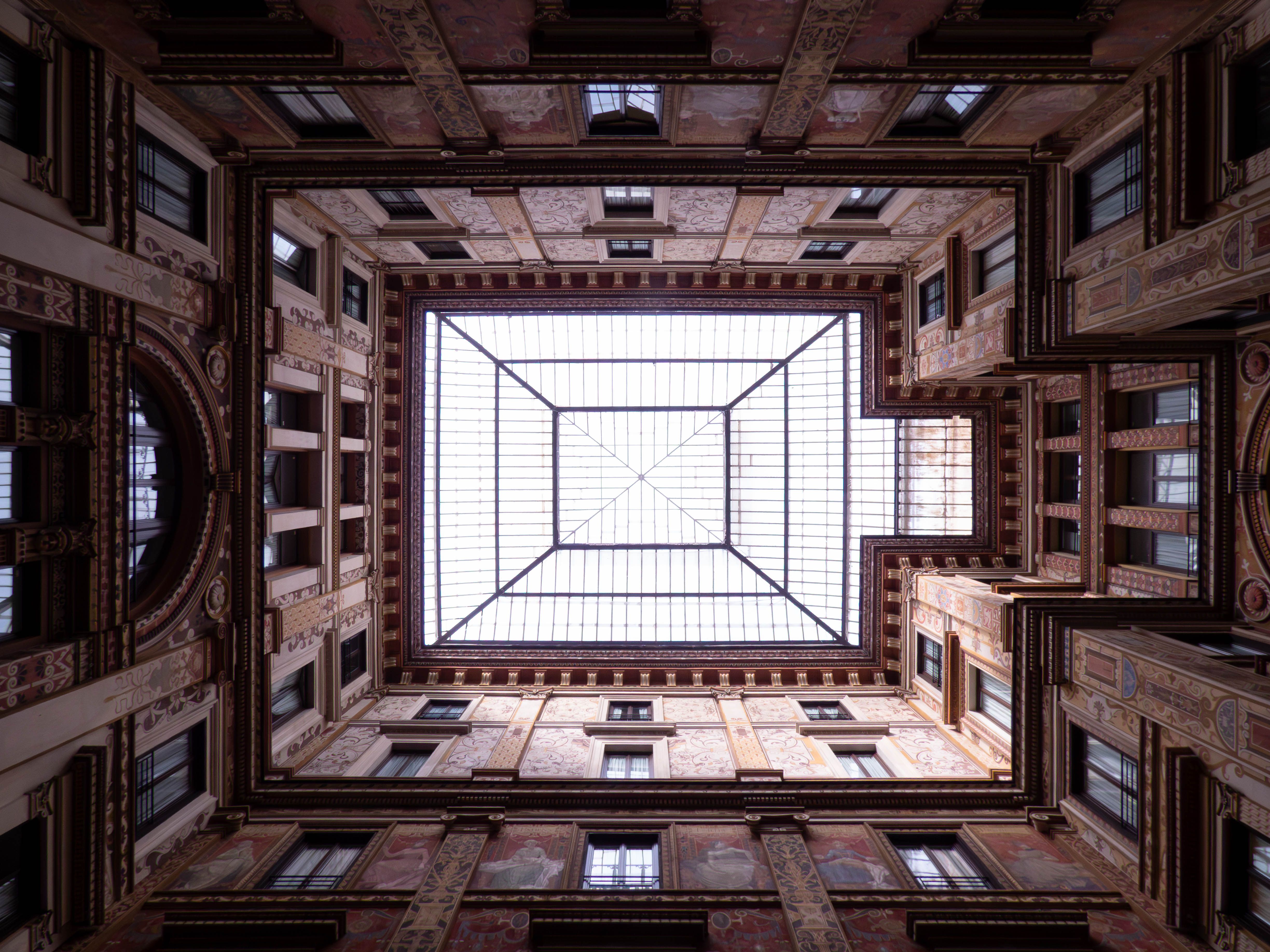 Cour intérieure d'un bâtiment classique sous une verrière, vue en contre-plongée