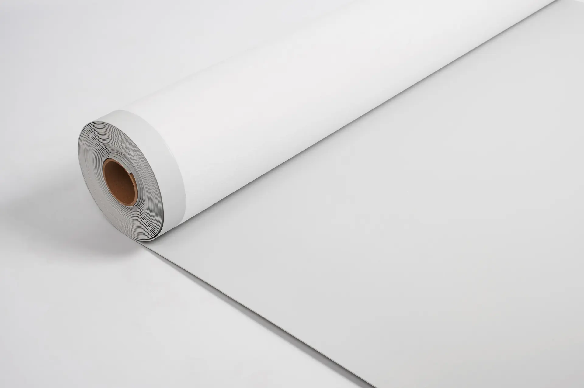 A large roll of white paper partially unrolled on a flat white surface.