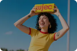 Woman laughing and holding a sign above her head representing energetic social media engagement