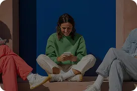 Woman sitting and reading a book against a blue wall representing thoughtful strategic marketing leadership