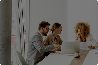 Two people shaking hands across a desk during a job interview