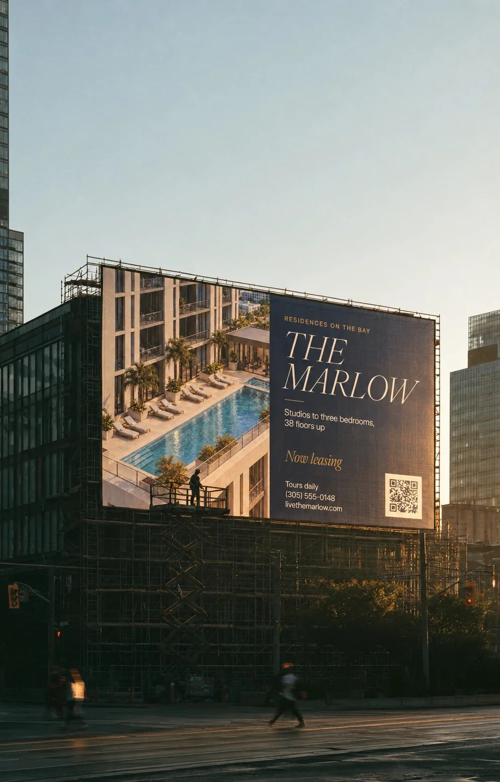 Billboard for The Marlow apartments above a building under construction at sunset