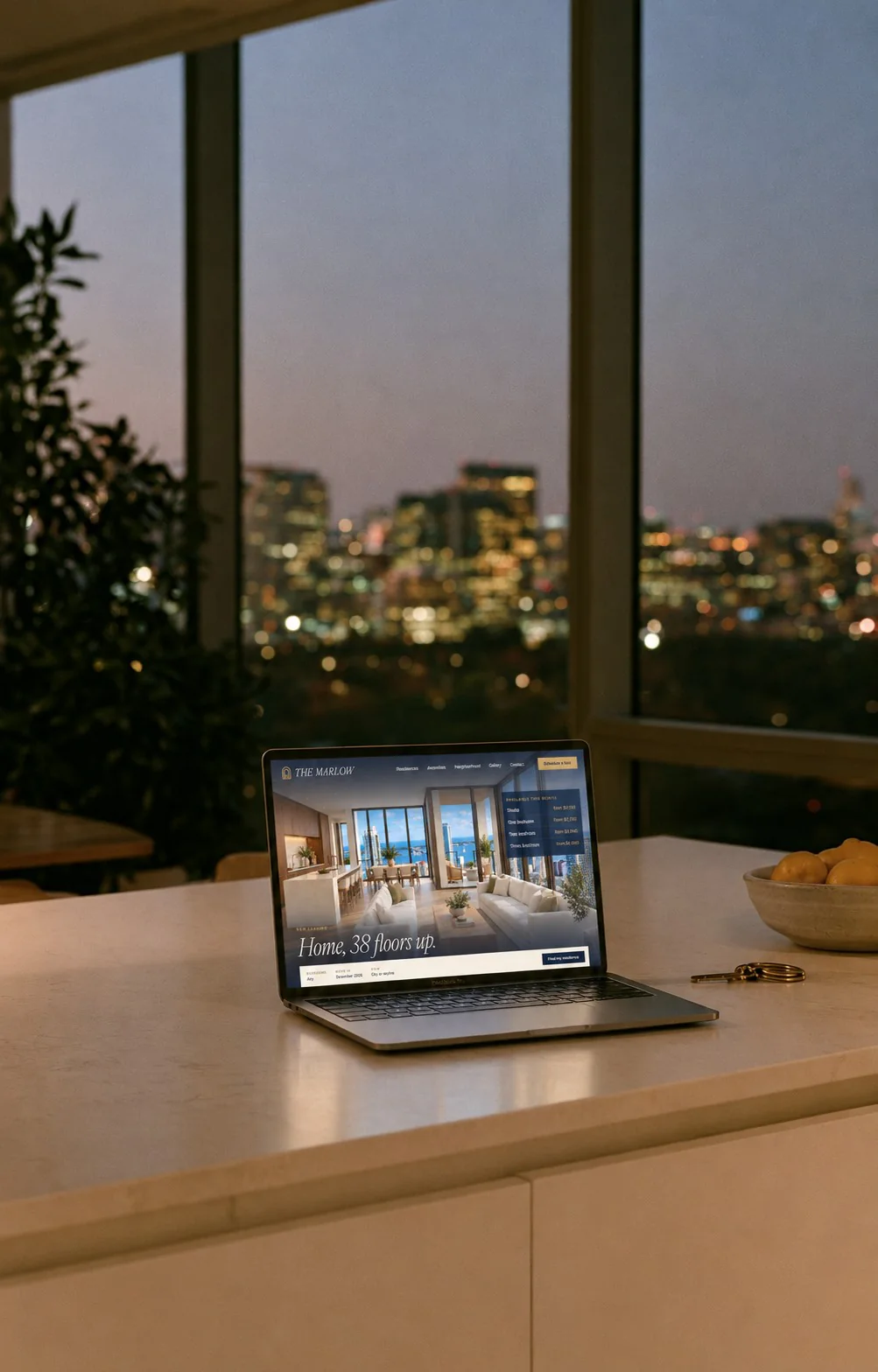 Laptop showing a property website on a kitchen counter with city lights at night