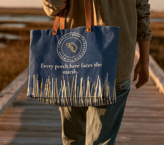 Person carrying a Tidewell tote on a marsh boardwalk