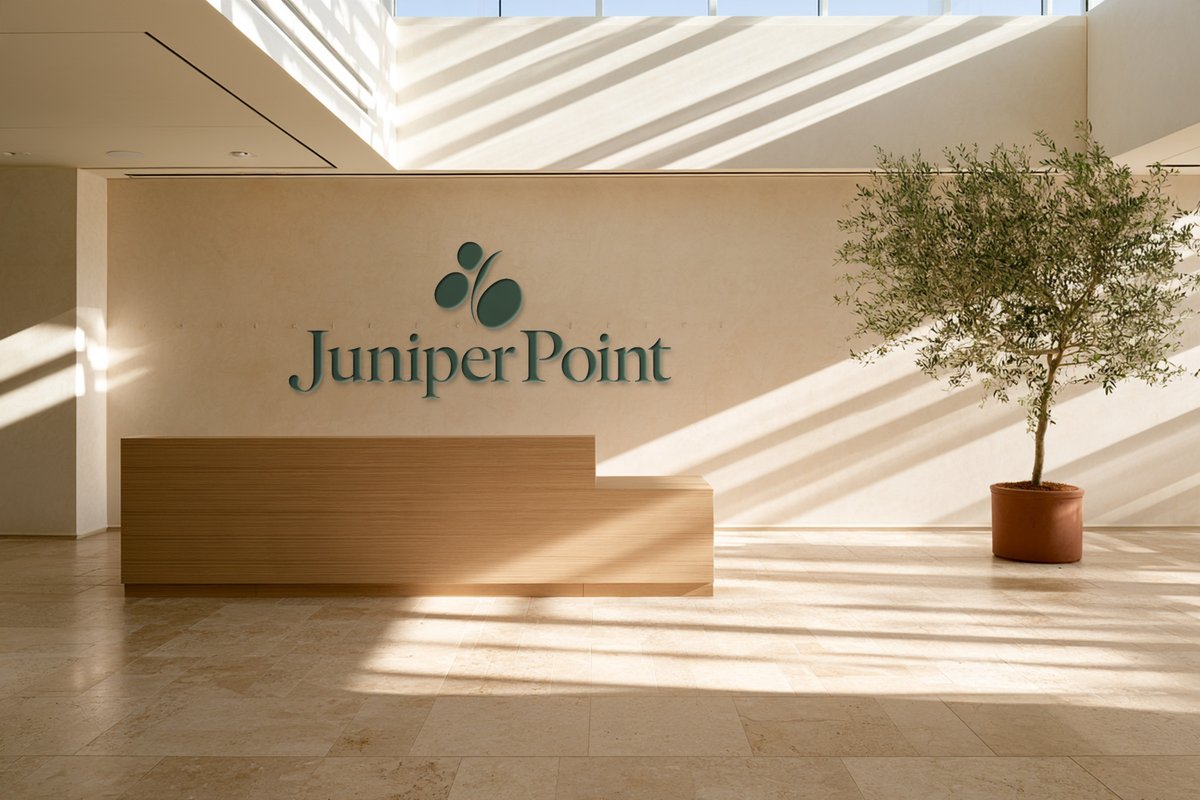 Juniper Point logo on a sunlit lobby wall