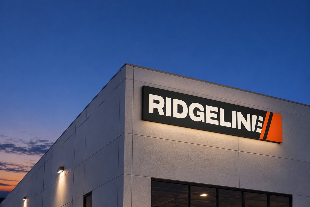 Ridgeline illuminated logo on a building at dusk
