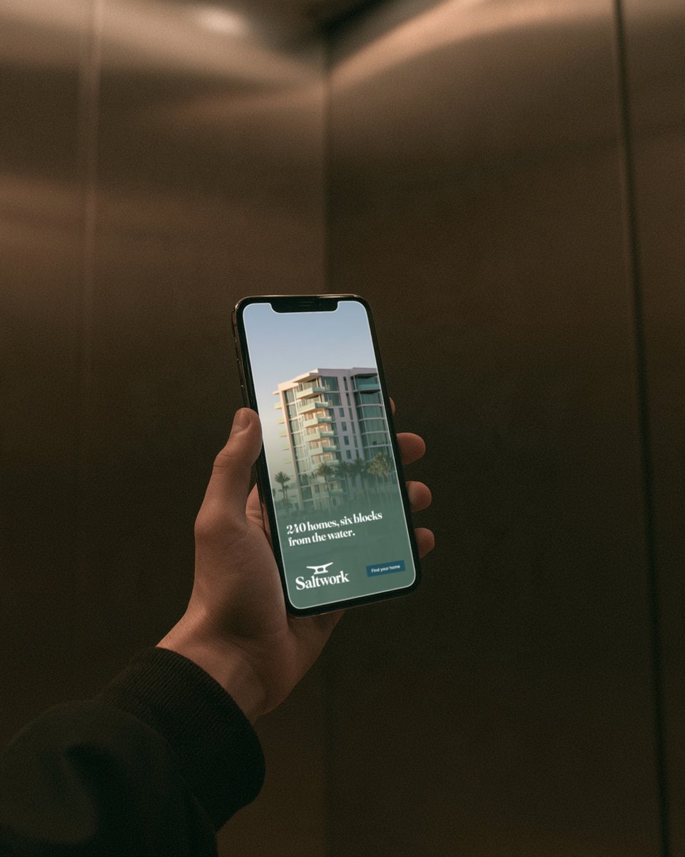Hand holding a phone with a Saltwork Instagram story ad