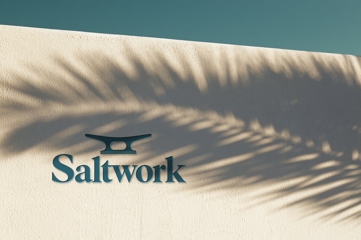 Saltwork logo on a white wall in palm shadow