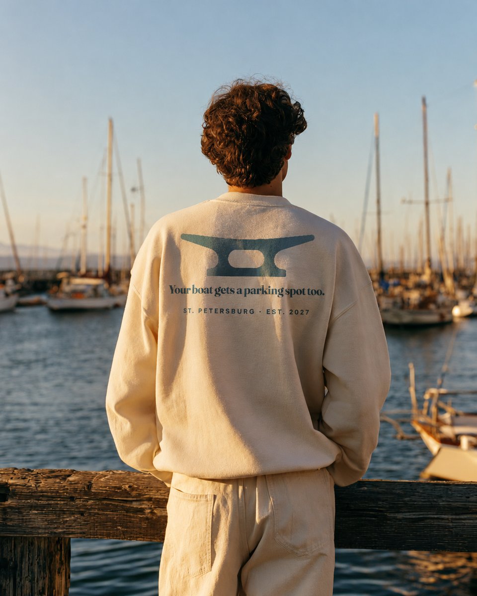 Man in a Saltwork sweatshirt looking over a marina