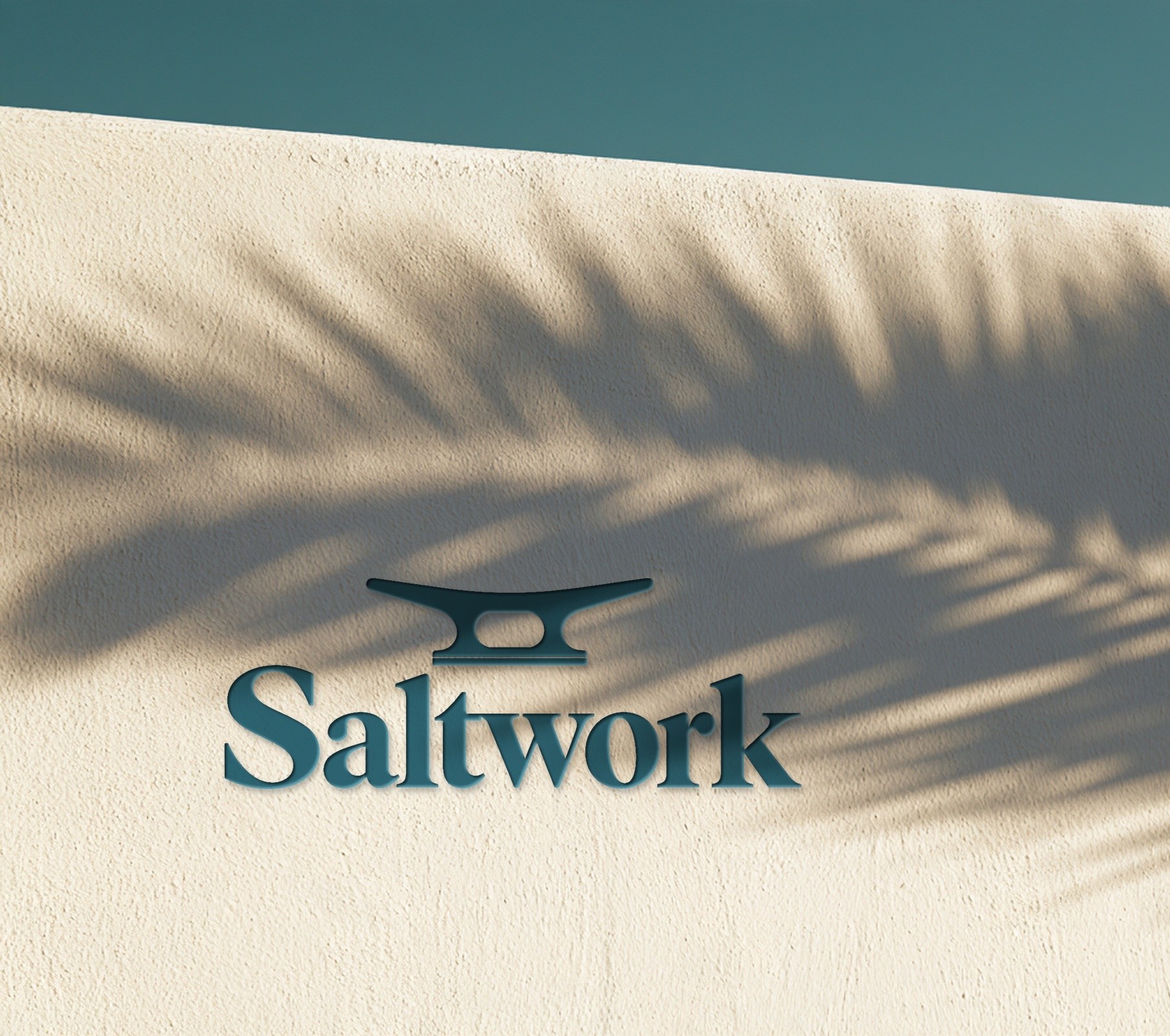 Saltwork logo on a white wall in palm shadow