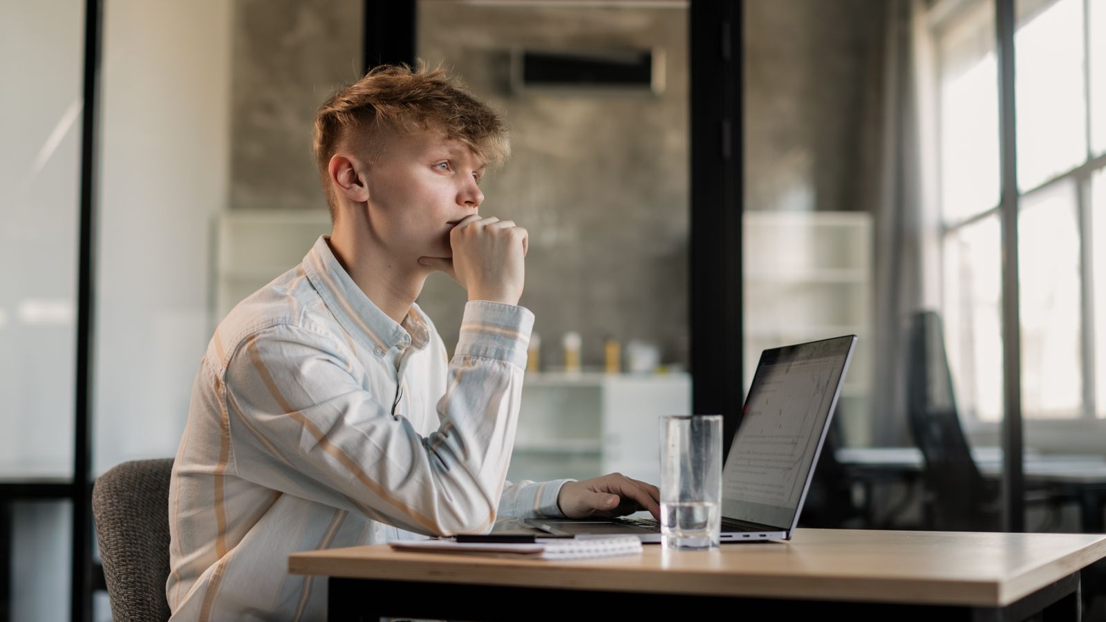 Entrepreneur e-commerce débutant pensif devant son ordinateur portable, illustrant les erreurs à éviter en e-commerce