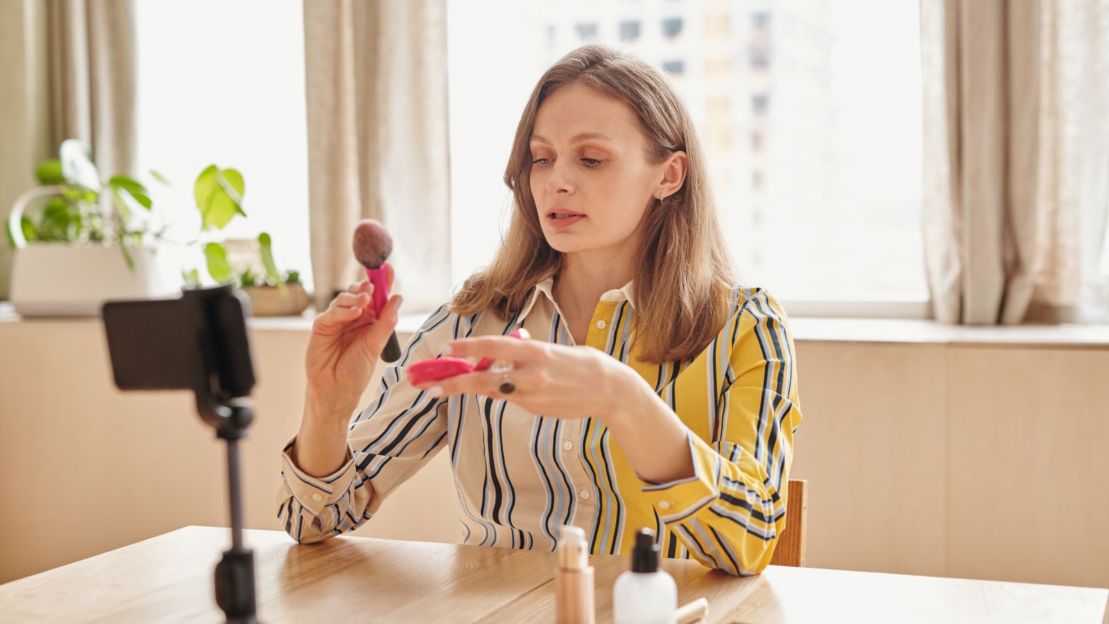 Créatrice filmant une démonstration produit au smartphone pour une créa publicitaire e-commerce