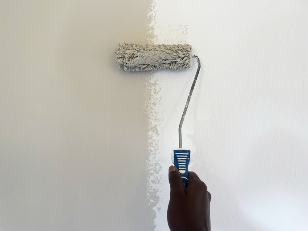 Peintre passant un rouleau sur un mur blanc