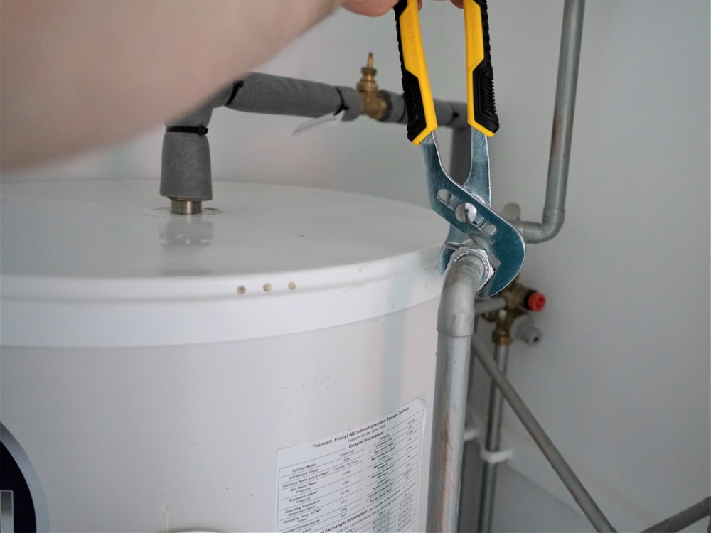 Plombier serrant un raccord sur un chauffe-eau