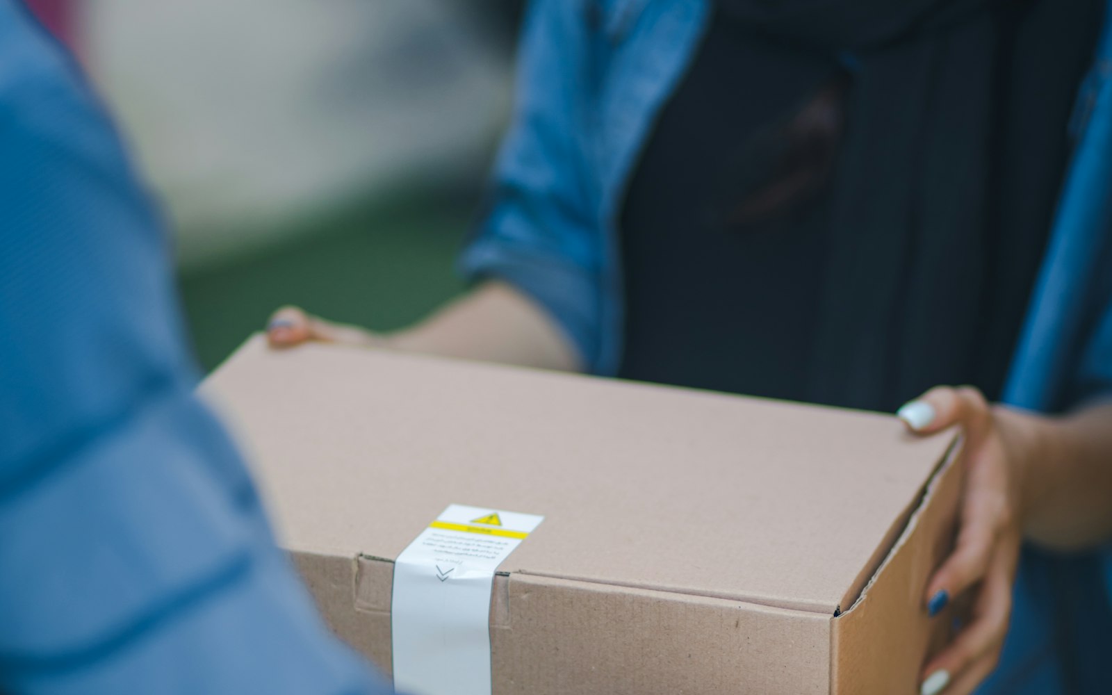 Livreur remettant un colis à une cliente, commandes e-commerce du Black Friday