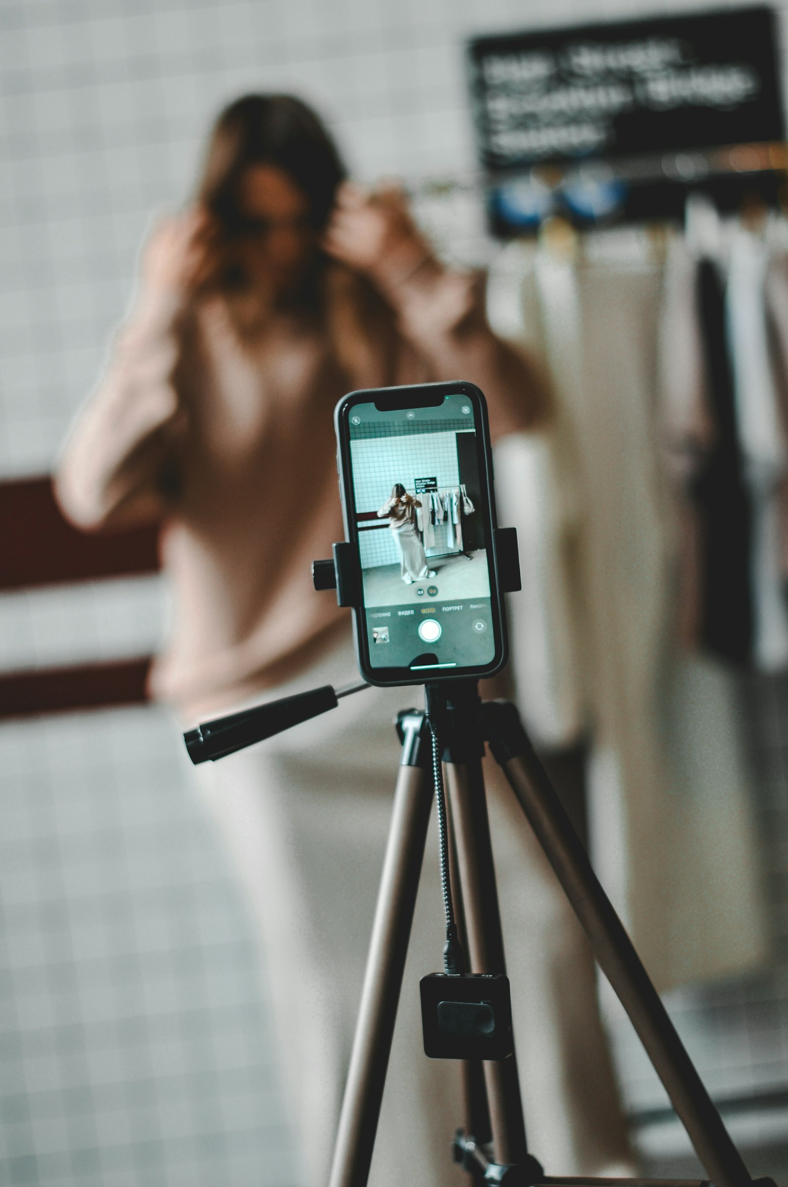 Créatrice UGC qui se filme avec un smartphone sur trépied pour une vidéo e-commerce