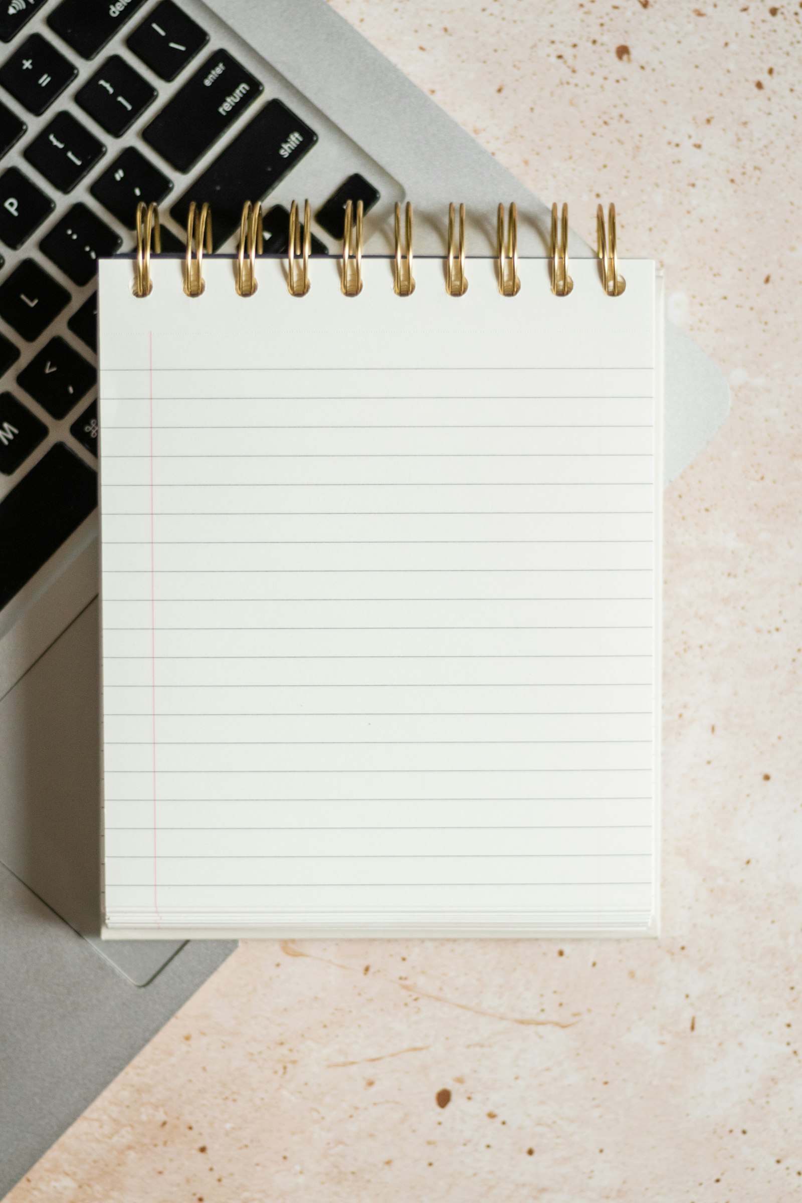 Ordinateur portable, carnet et calendrier sur un bureau pour organiser le suivi UTM des campagnes Meta Ads sur Shopify