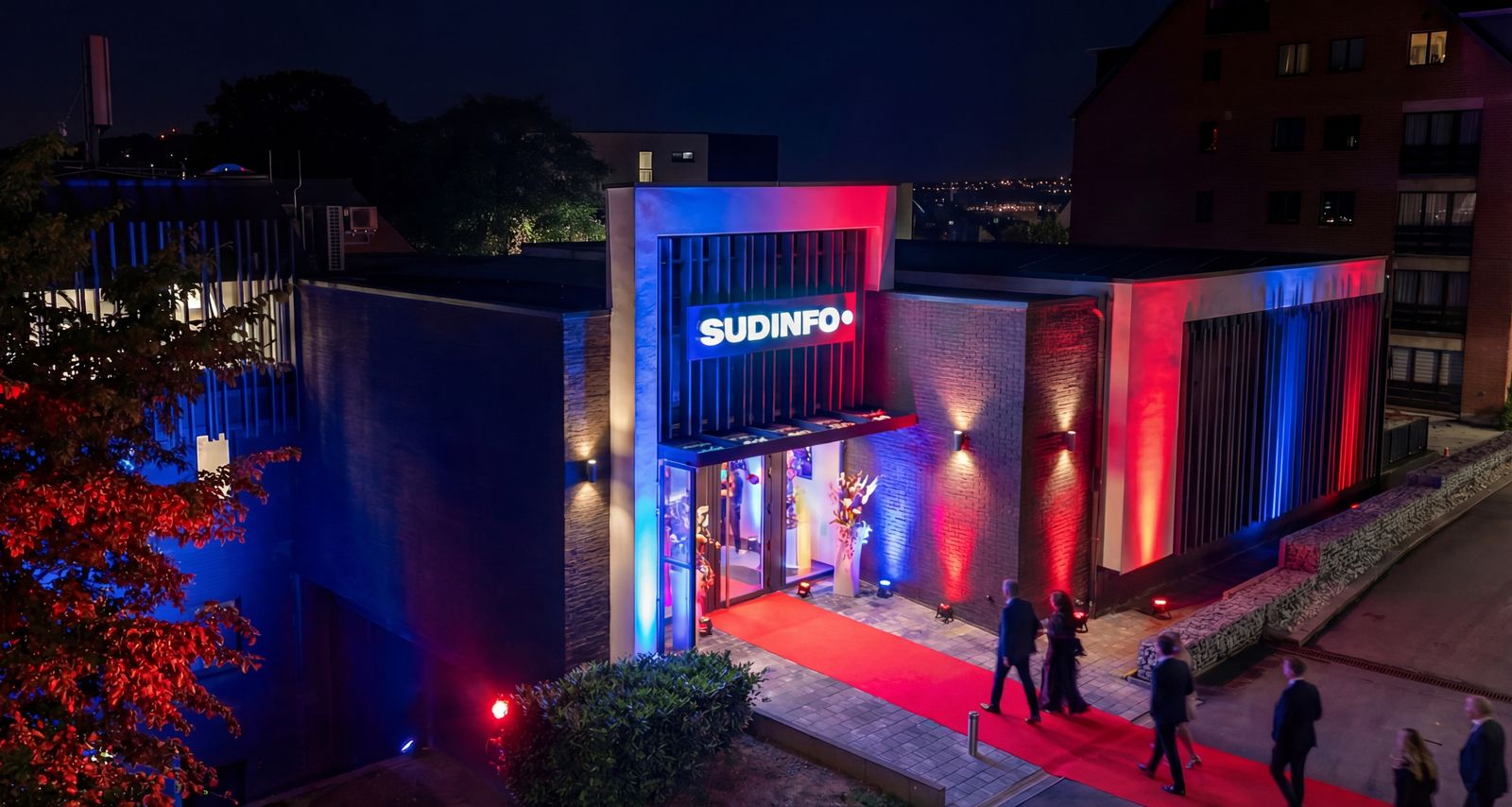Bâtiment Sudinfo éclairé de nuit avec tapis rouge pour un événement